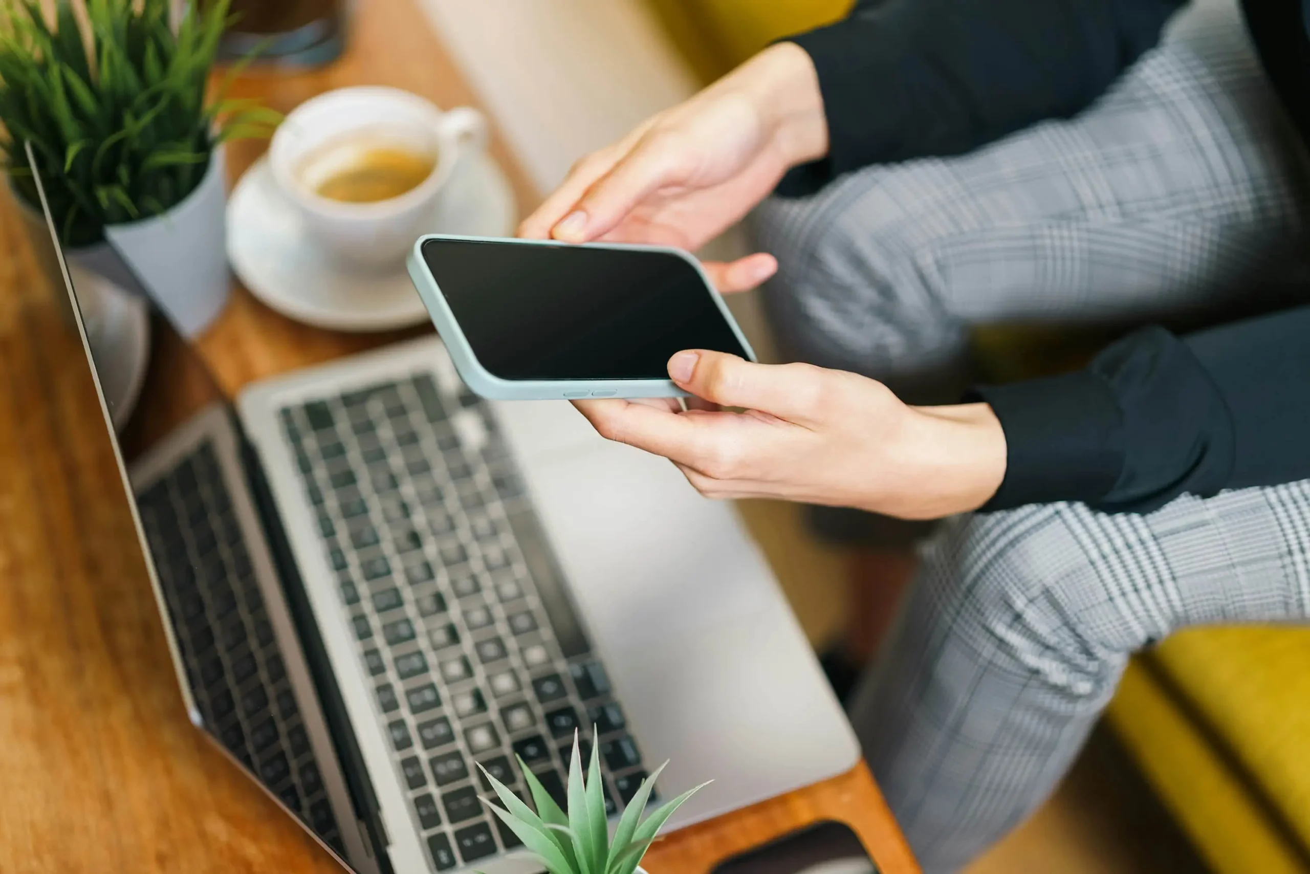 Hands holding smartphone next to laptop representing Match.com platform review